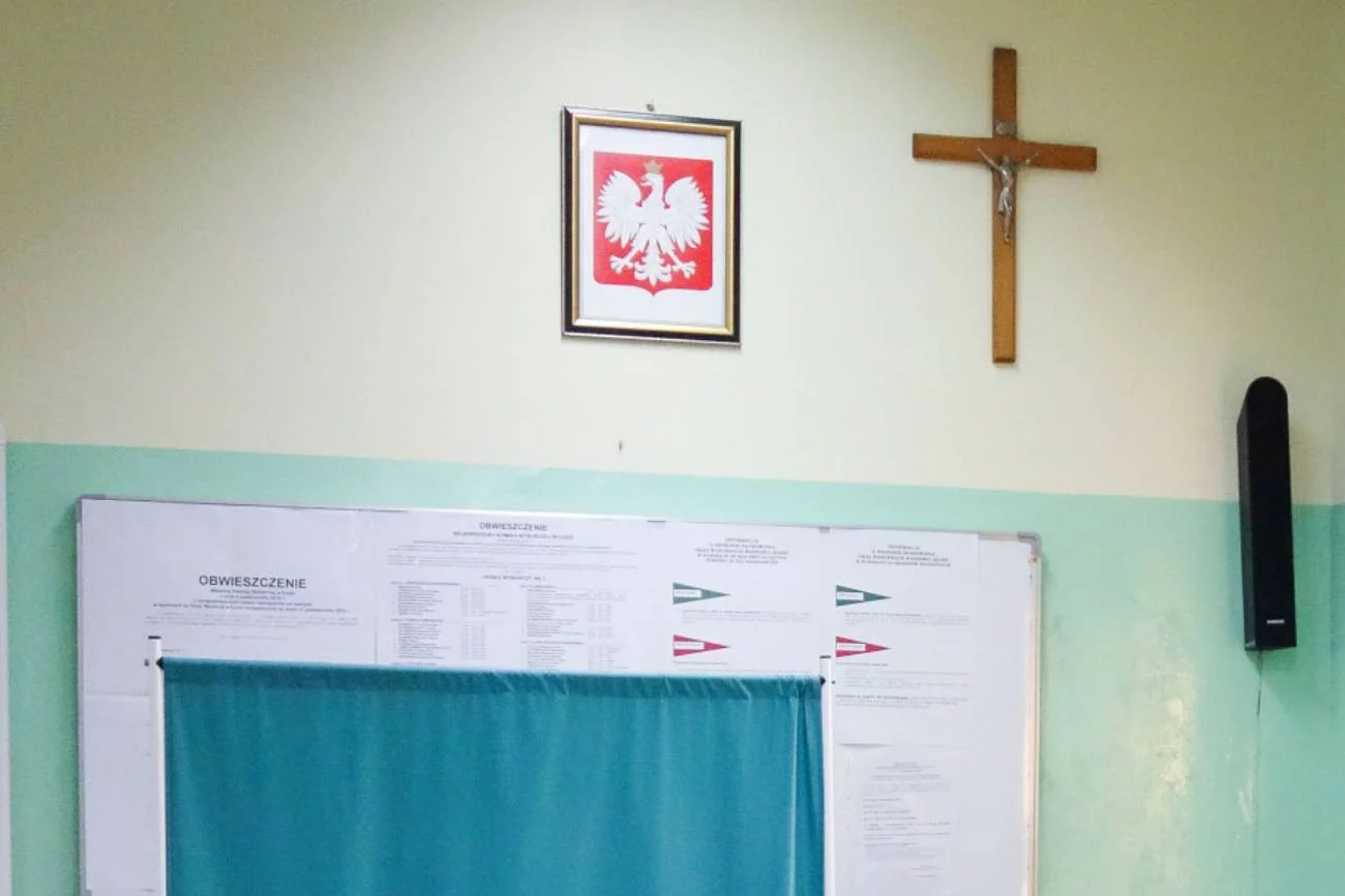 Szkolna klasa z krzyżem na ścianie.