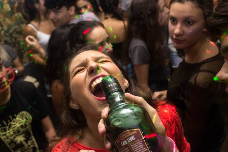 Nastolatkowie piją alkohol na imprezie