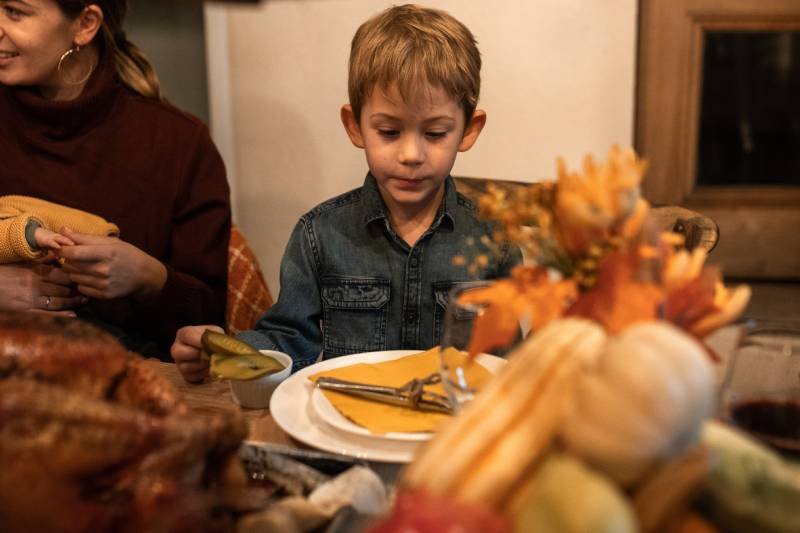 Jesienny obiad, chłopiec je krem z dyni