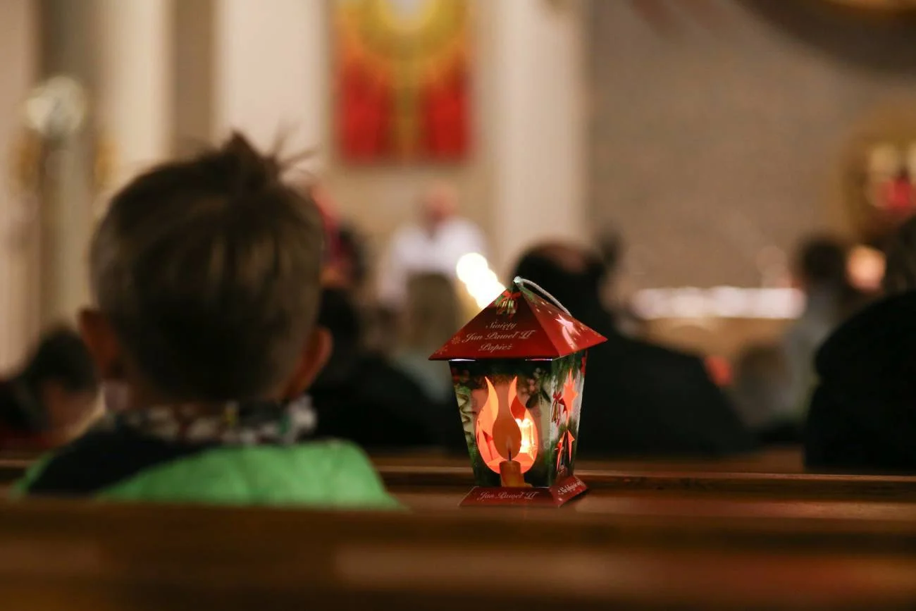 Chłopiec na roratach w kościele z lampionem.