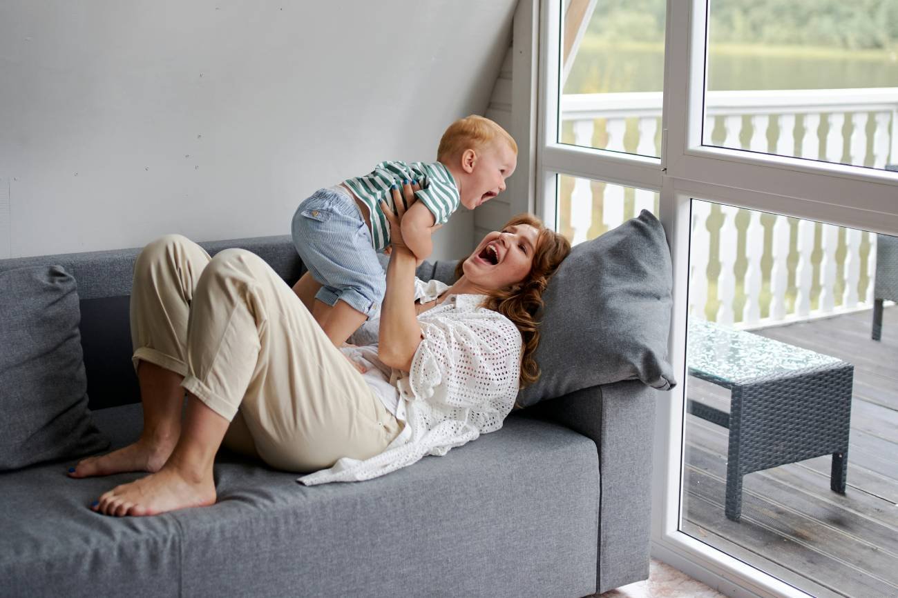Mama i dziecko leżą na łóżku i cieszą się ze wspólnych chwil razem.