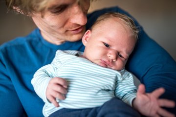 Pępkowe: tata trzyma noworodka na rękach