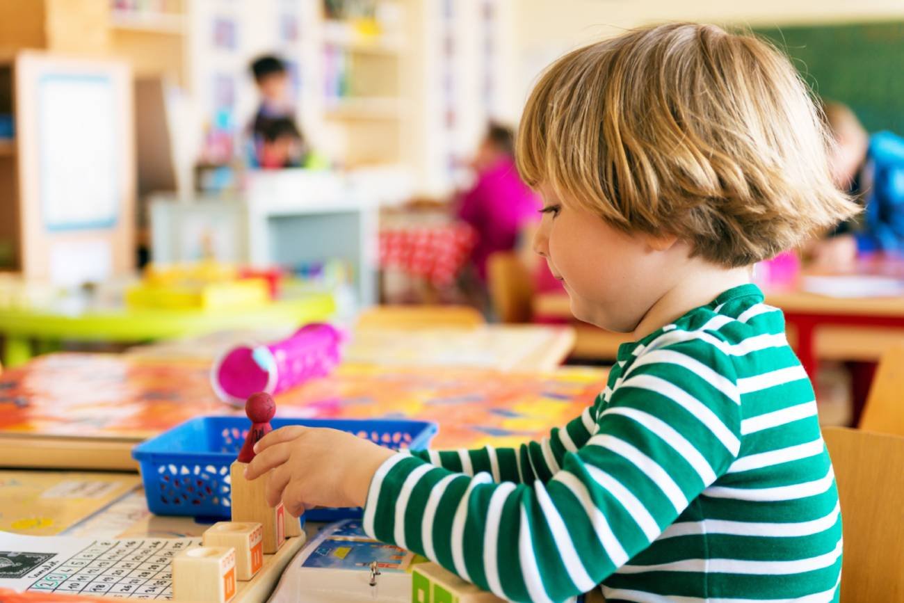 Chłopiec bawi się w przedszkolnej sali.