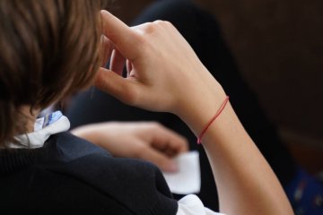 Nastolatek z czerwonym sznurkiem na nadgarstku. Nastolatek z czerwonym sznurkiem na nadgarstku.