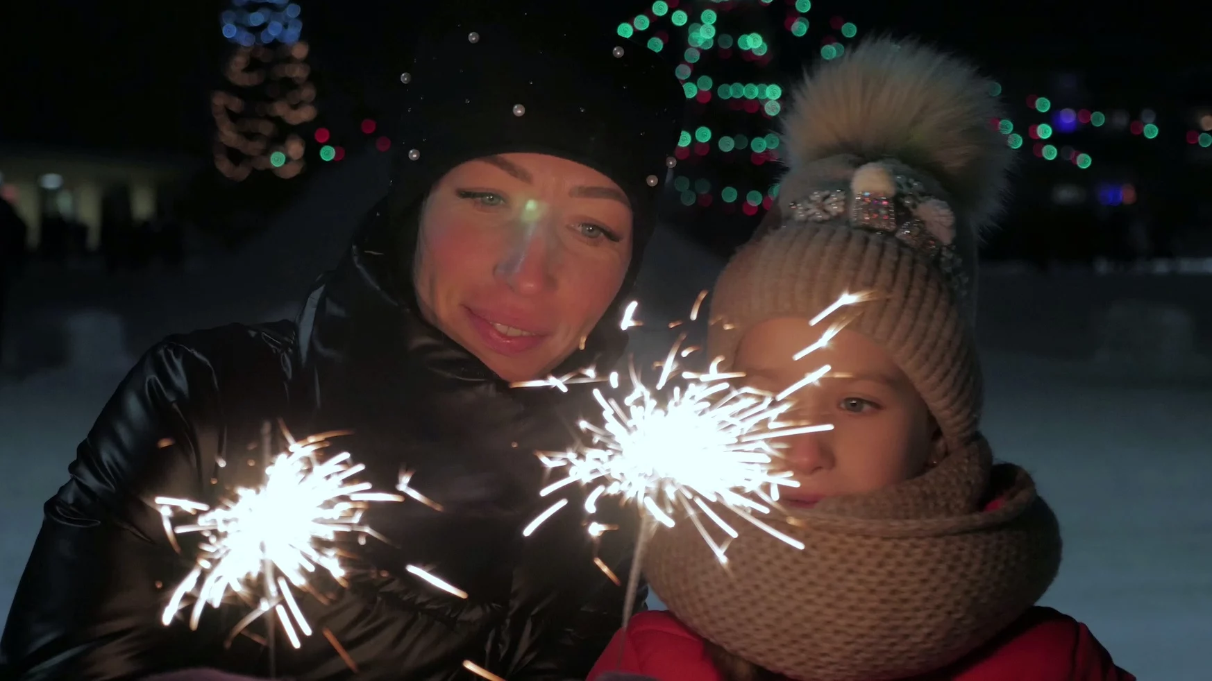 Na zdjęciu mama z dzieckiem zapalają zimne ognie