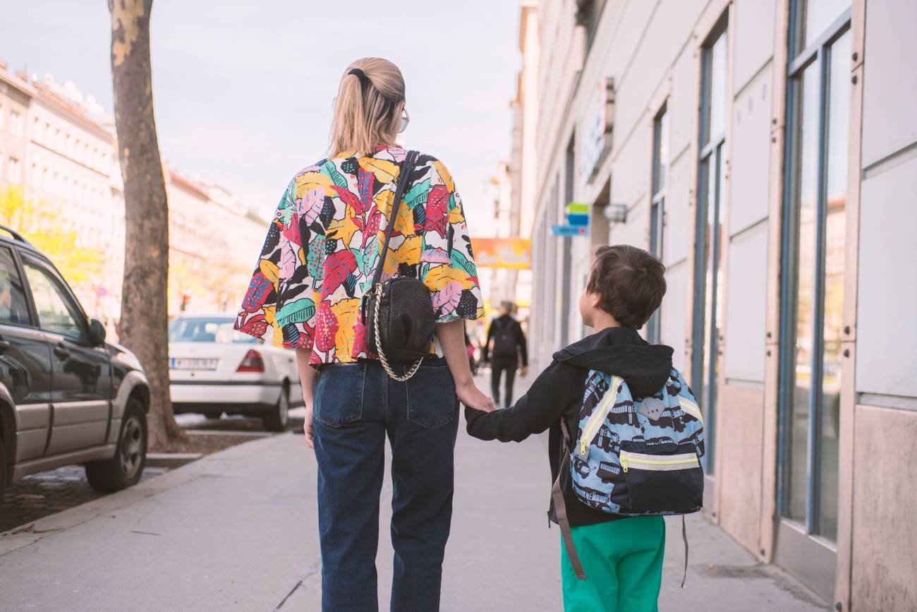 Kobieta z dzieckiem idzie przez miasto.