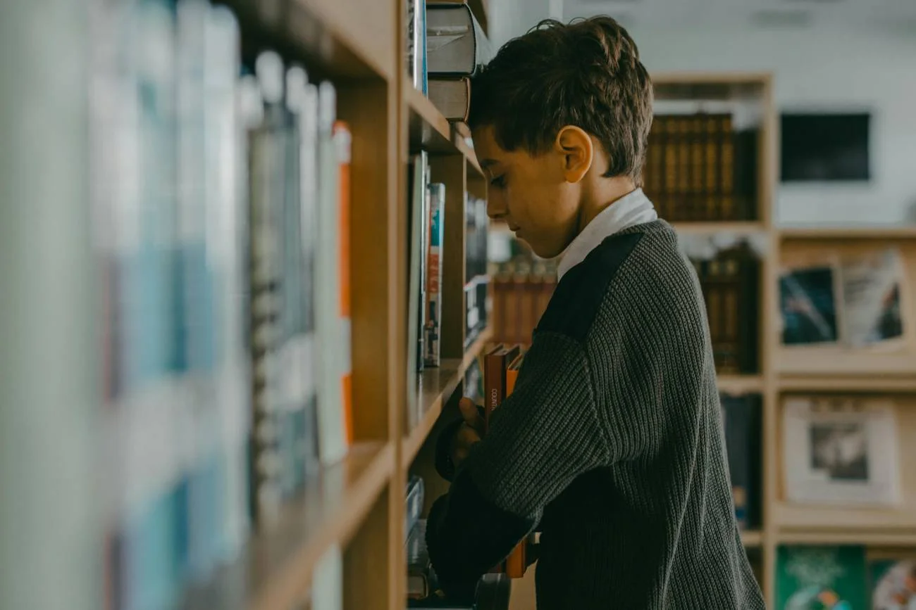 smutny chłopiec w szkolnej bibliotece