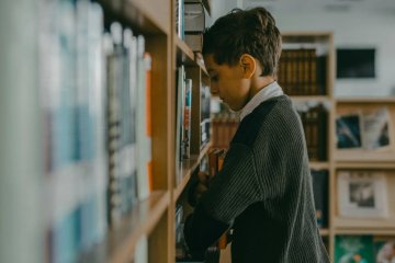 smutny chłopiec w szkolnej bibliotece