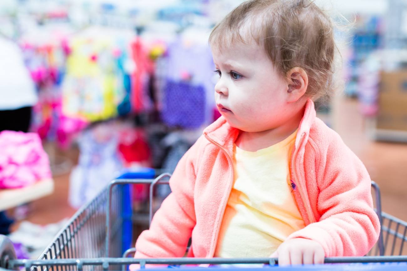 Małe dziecko w sklepowym wózku.