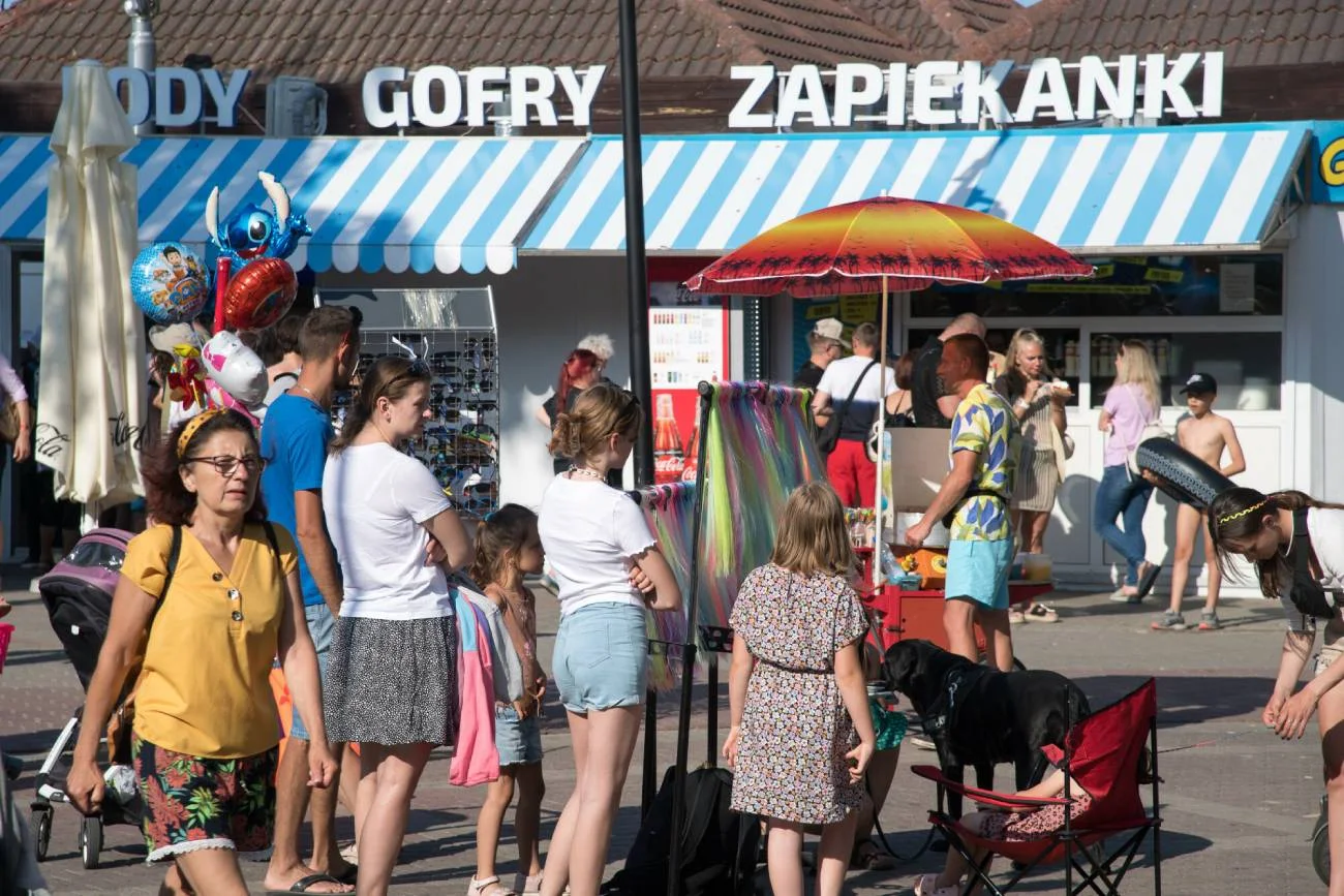 Dzieci czekają w kolejce, żeby kupić lody z automatu.