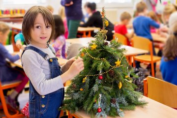 Uczniowie stroją klasę na święta. Uczniowie ubierają choinkę.