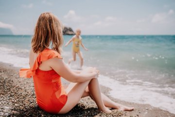 Kobieta na wakacjach na plaży z dzieckiem przyjaciółki.