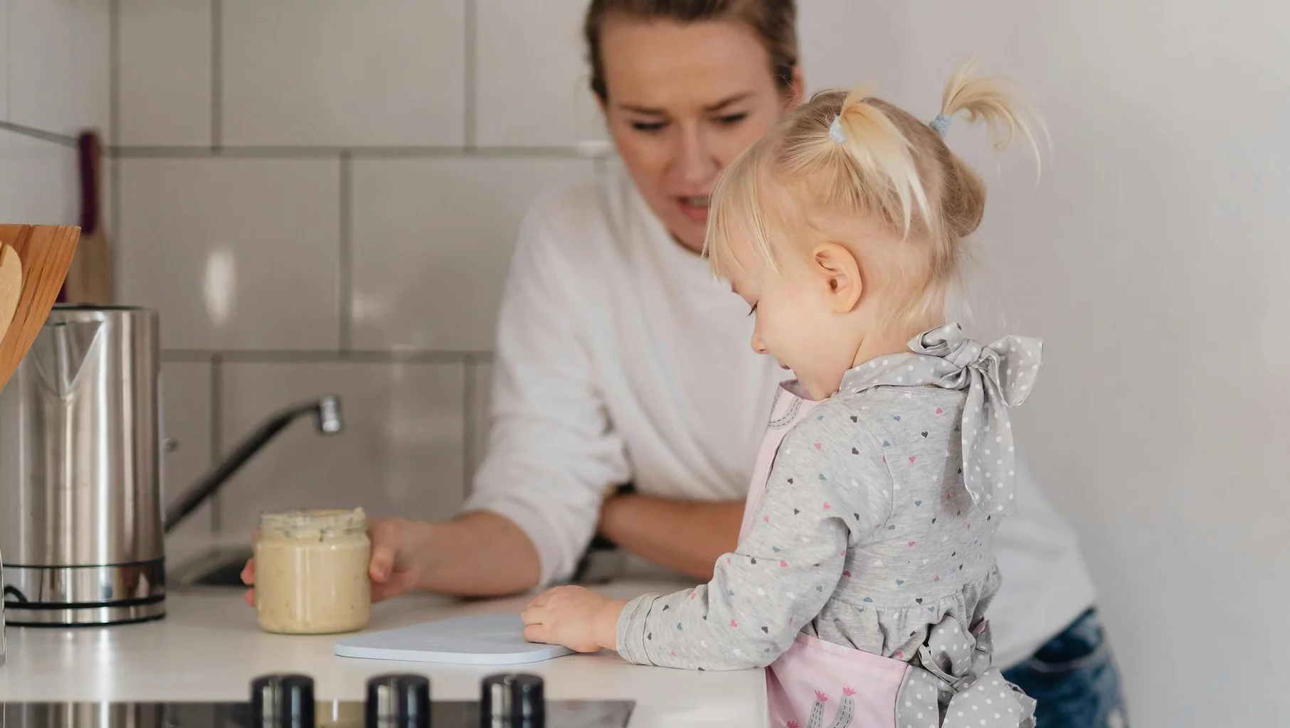 Na zdjęciu kobieta z dzieckiem przygotowuje posiłek w domu.