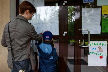 Mama z dzieckiem sprawdzają listy w przedszkolu. Mama z dzieckiem sprawdzają listy w przedszkolu.