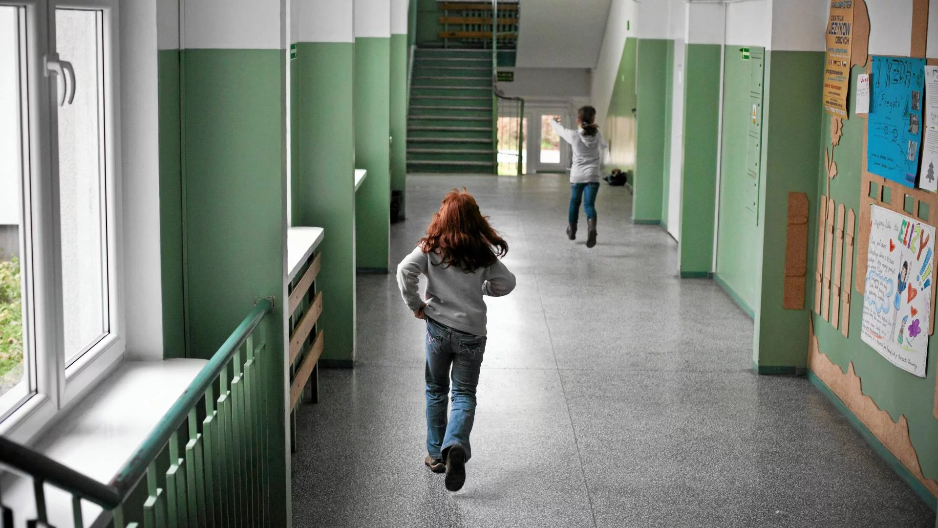 uczniowie idą szkolnym korytarzem uczniowie idą szkolnym korytarzem