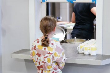 Uczennica czeka na wydanie posiłku na stołówce. Uczennica czeka na wydanie posiłku na stołówce.