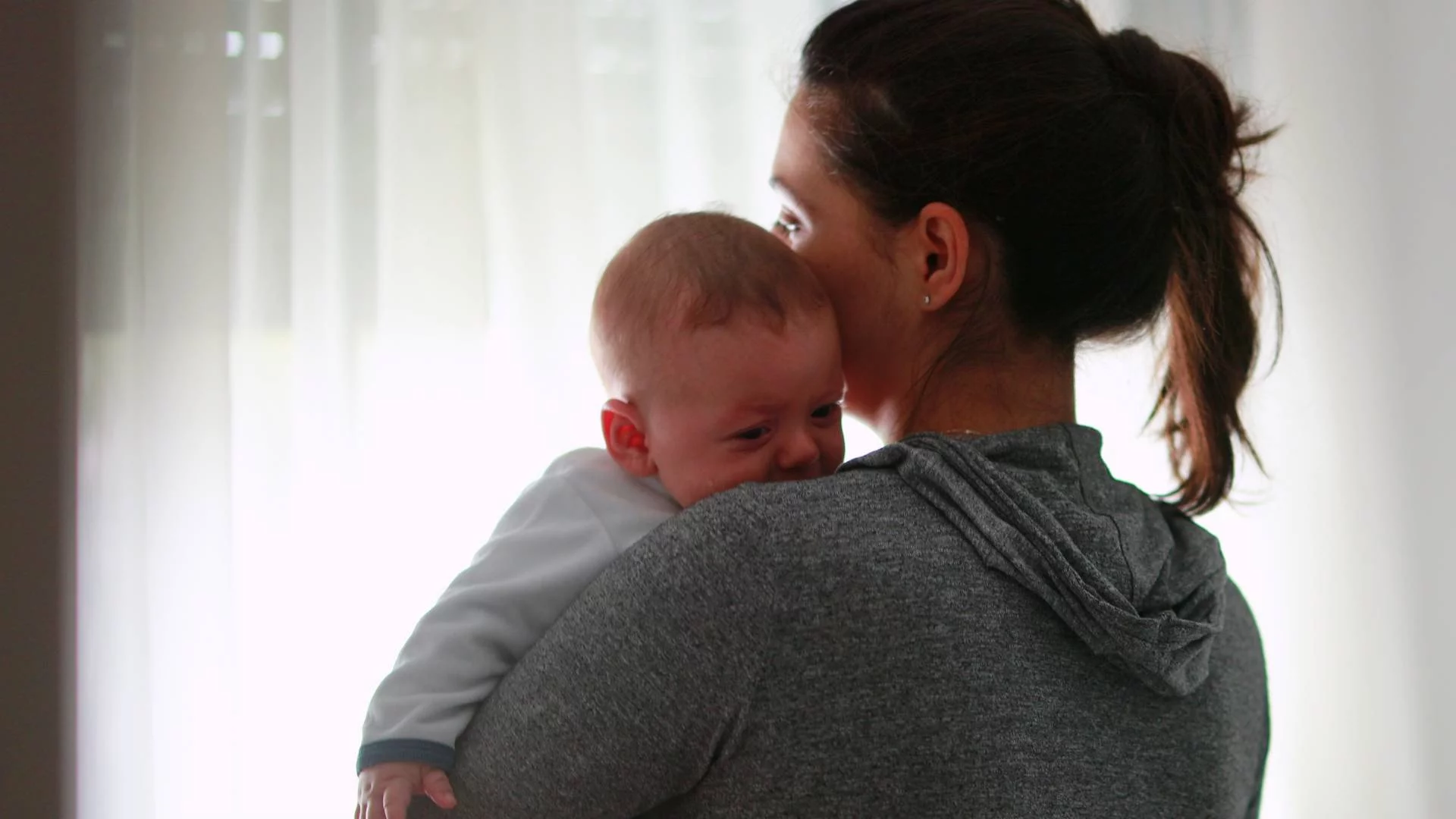 zmęczona mama nosi na rękach niemowlę zmęczona mama nosi na rękach niemowlę