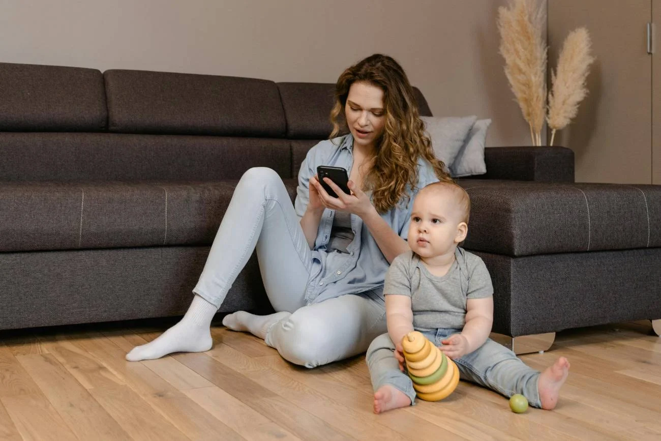 Młoda mama ze smartfonem w ręku.