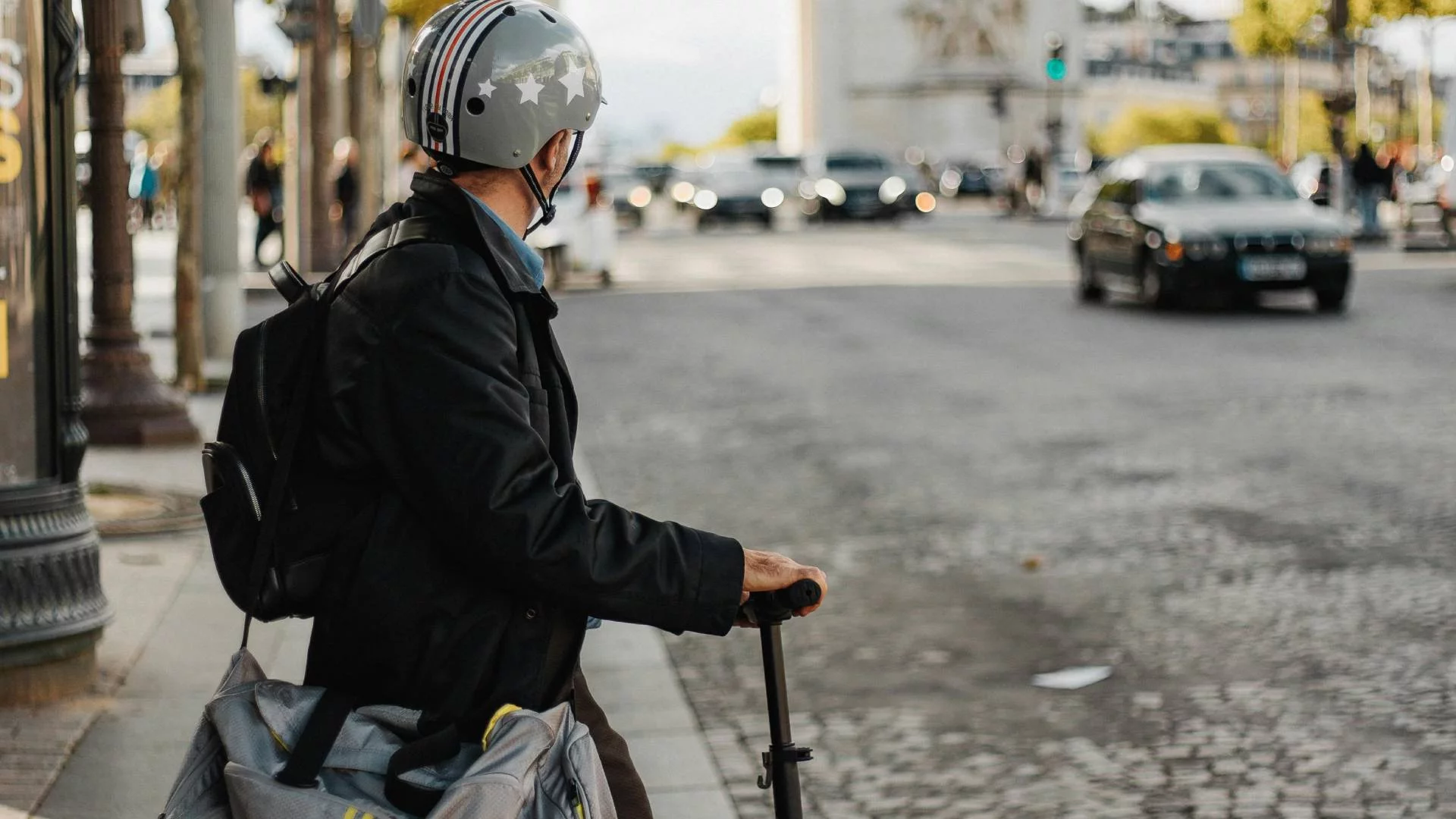 młody chłopak stoi przy ulicy z hulajnogą elektryczną młody chłopak stoi przy ulicy z hulajnogą elektryczną