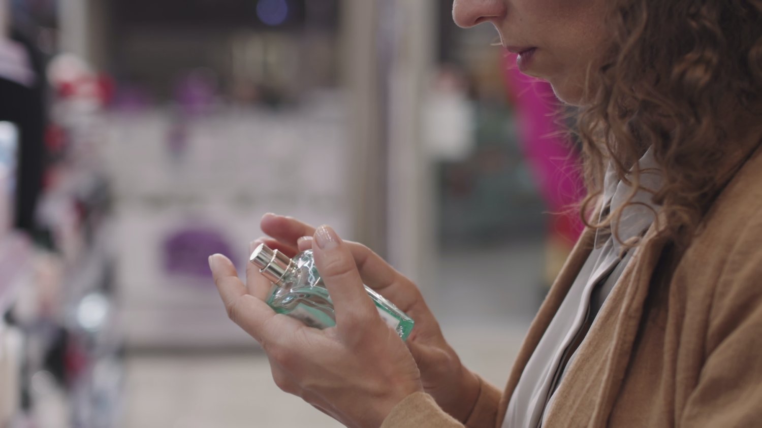 5 najtrwalszych arabskich perfum z Rossmanna. Na mnie trzymają się cały dzień. Na zdjęciu kobieta wybiera perfumy w Rossmannie.