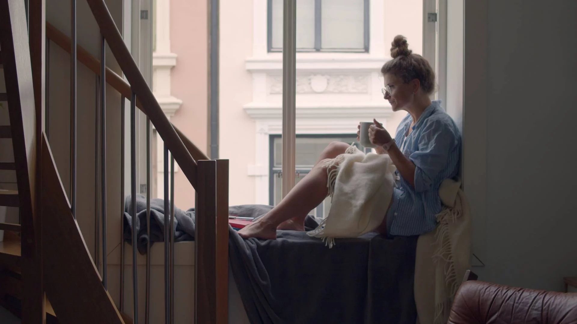 kobieta odpoczywa z kubkiem kawy, siedząc na parapecie kobieta odpoczywa z kubkiem kawy, siedząc na parapecie