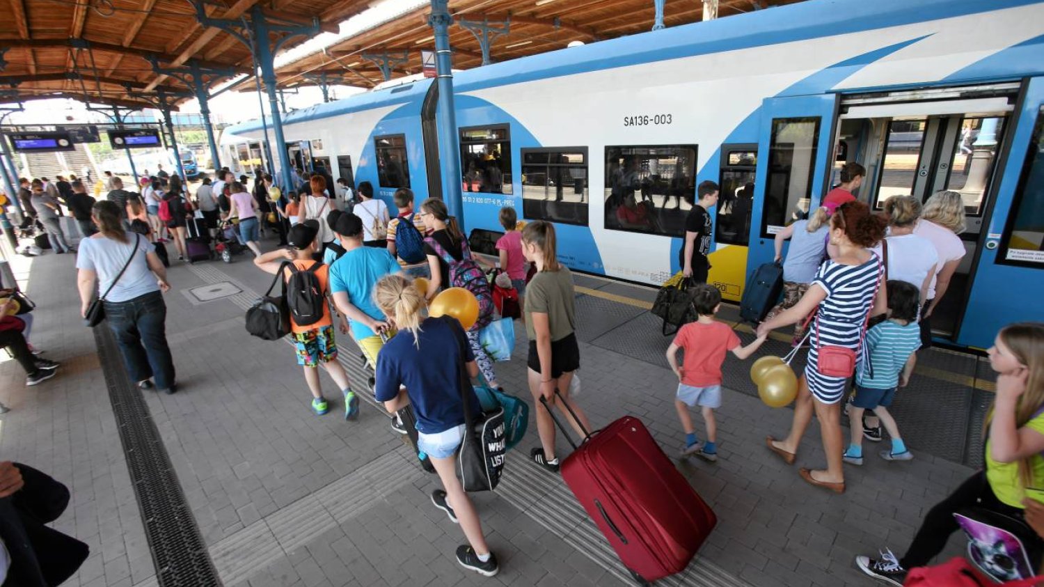 dzieci wsiadają do pociągu – wyjazd na kolonie