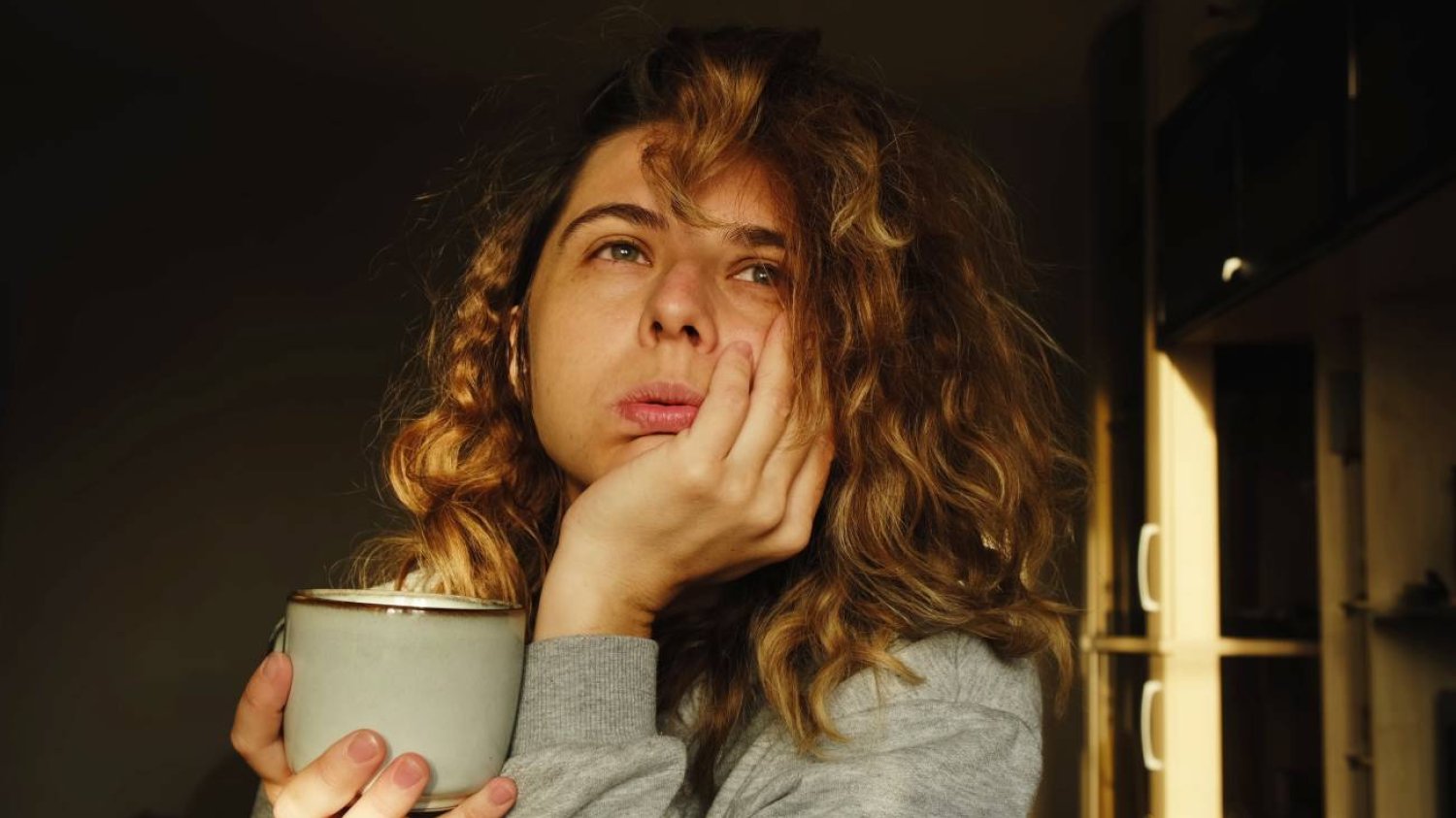 Zmęczona, smutna mama pije kawę i patrzy w dal Zmęczona, smutna mama pije kawę i patrzy w dal