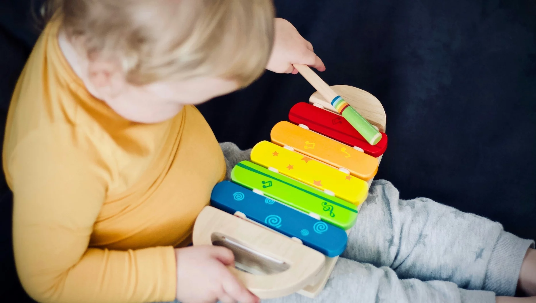 Na zdjęciu małe dziecko "gra na cymbałkach".