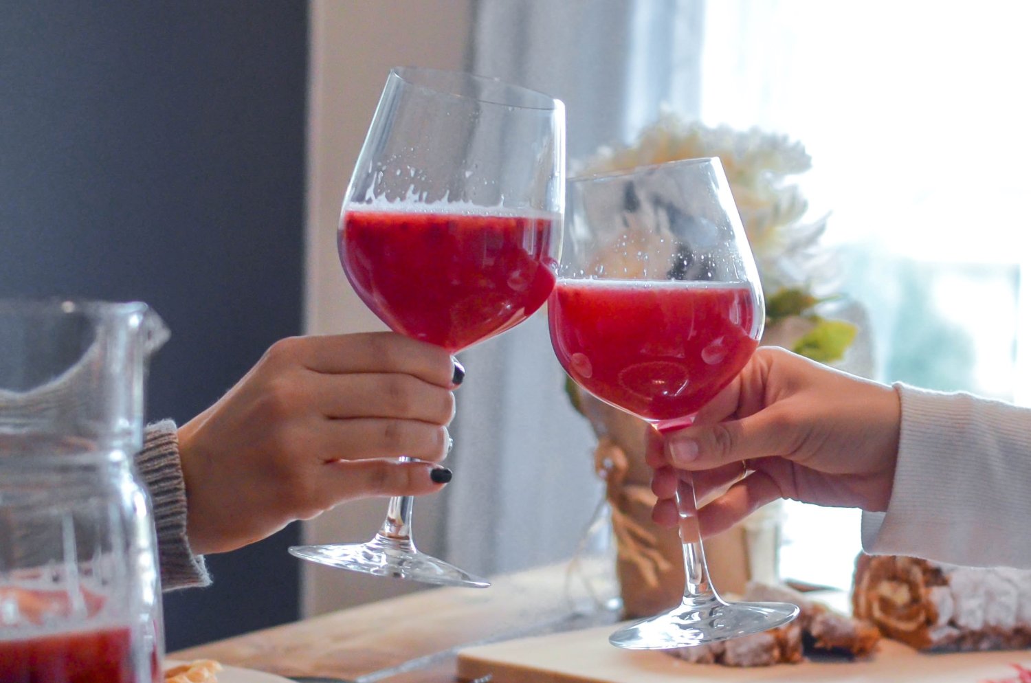 Czerwony napój w kieliszkach, dłonie, toast