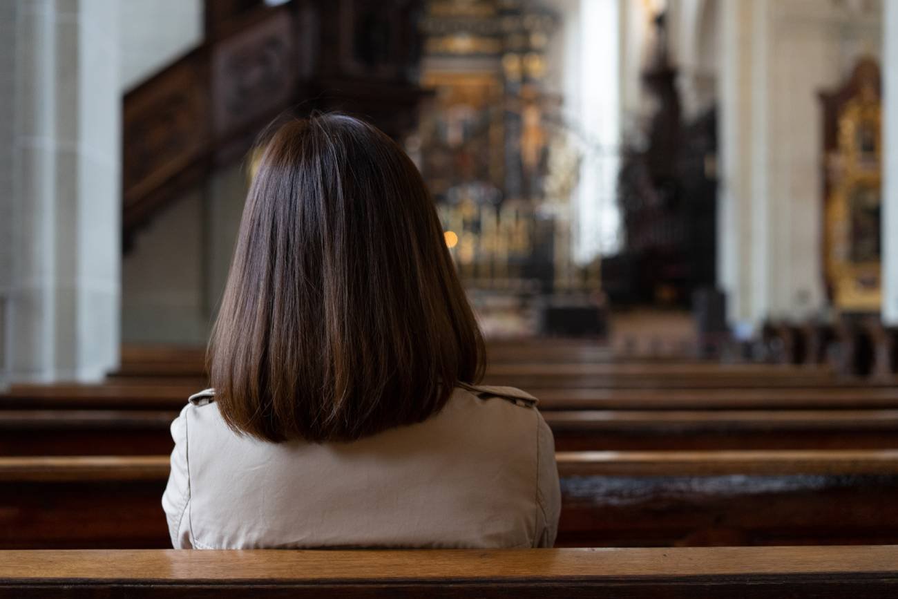 Kobieta modląca się w kościele.