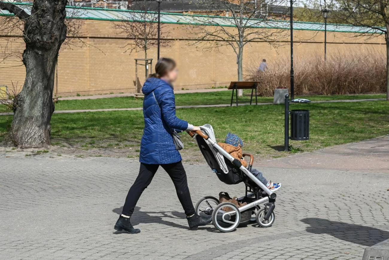 Matka z niemowlakiem w wózku na spacerze. Matka z niemowlakiem w wózku na spacerze.
