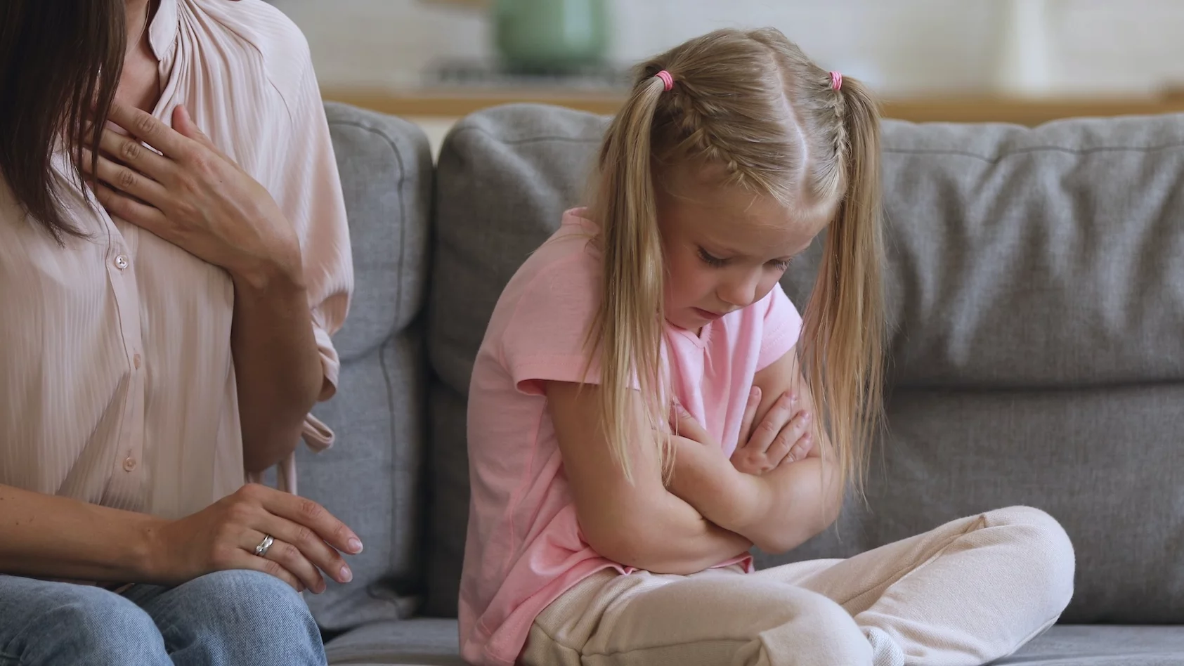 Mama z córką siedzą na kanapie. Mama poucza córkę.