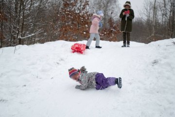 Babcia pilnuje wnuków podczas zabawy na śniegu. Babcia pilnuje wnuków podczas zabawy na śniegu.