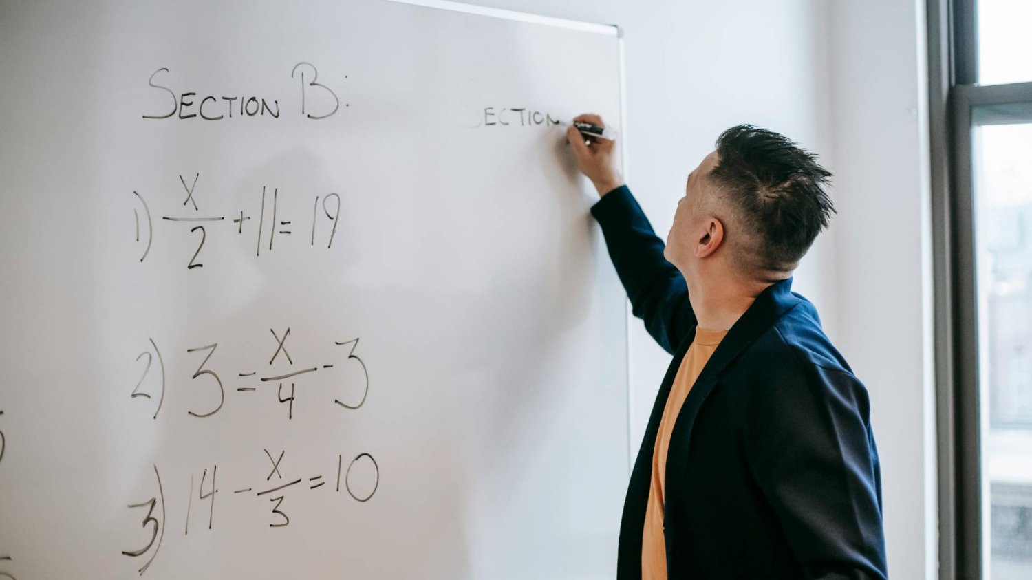 nauczyciel matematyki pisze na tablicy równania nauczyciel matematyki pisze na tablicy równania