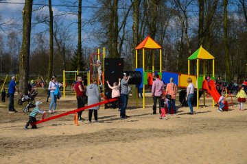 Dzieci bawią się na placu zabaw w brudnym piachu.