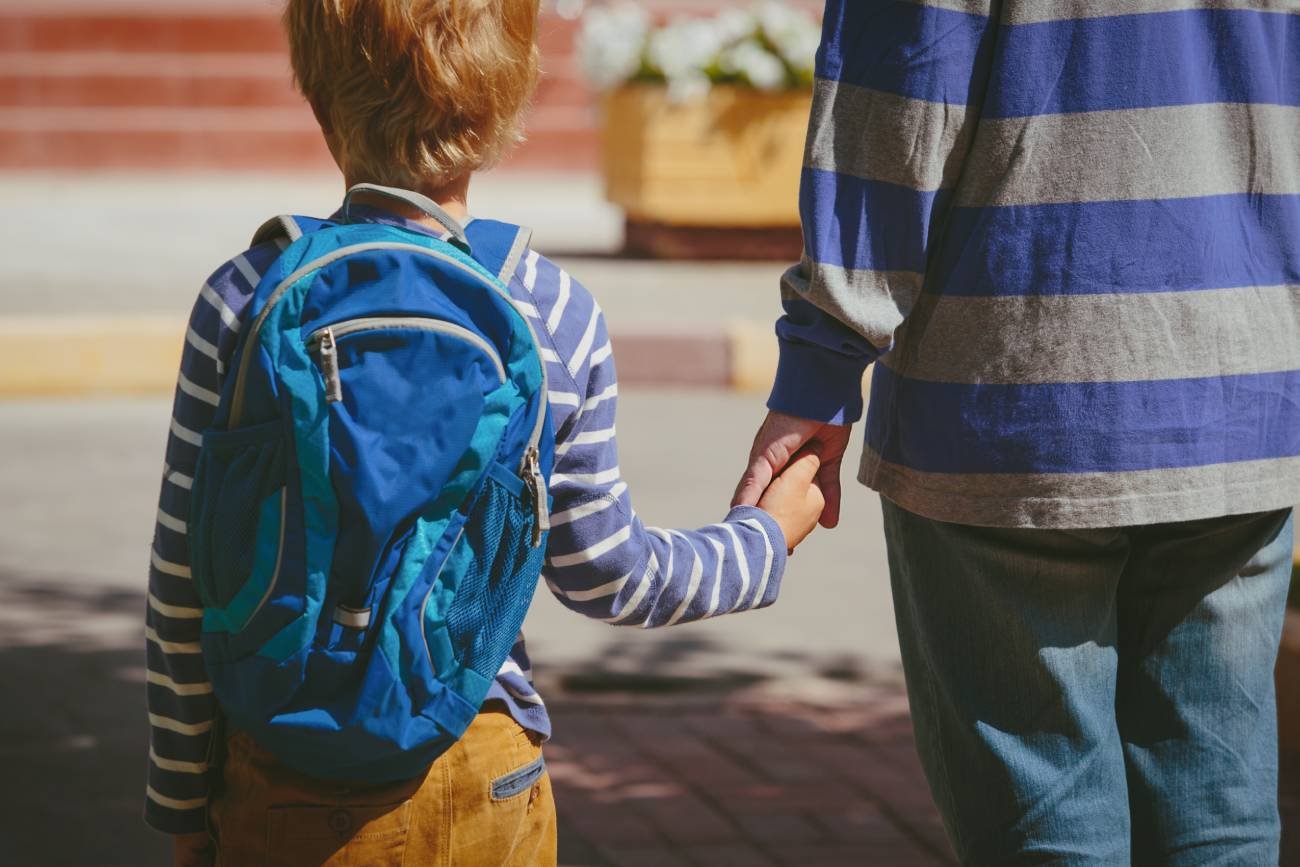 Dziecko z rodzicem idzie do szkoły.