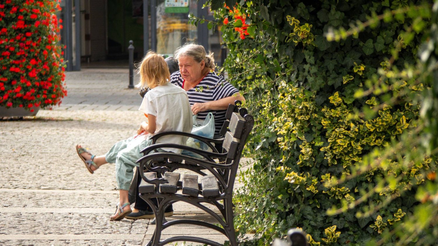 babcia z wnuczką rozmawia, siedząc na ławce babcia z wnuczką rozmawia, siedząc na ławce