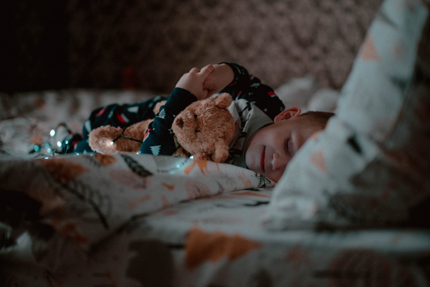 Dziecko w łóżku, z grymasem na twarzy.