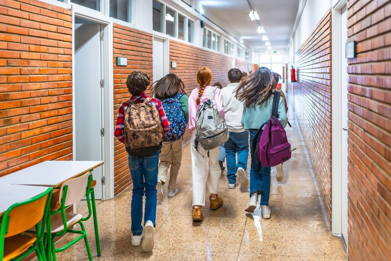 Uczniowie biegną korytarzem podczas przerwy.