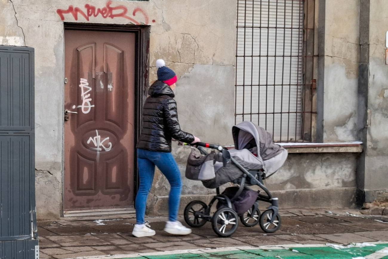 Rodzic z wózkiem na spacerze. Rodzic z wózkiem na spacerze.