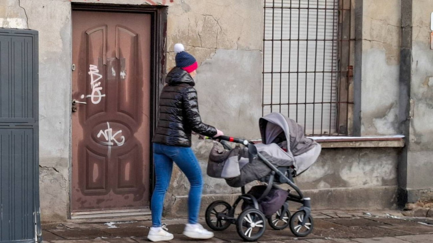 Rodzic z wózkiem na spacerze. Rodzic z wózkiem na spacerze.