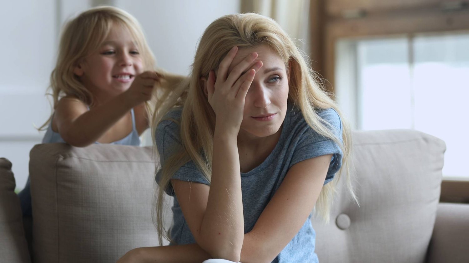 zmęczona mama próbuje odpoczywać na kanapie, a dziecko ją zaczepia zmęczona mama próbuje odpoczywać na kanapie, a dziecko ją zaczepia