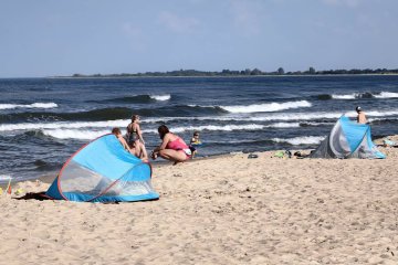Plażowicze odpoczywają nad morzem.
