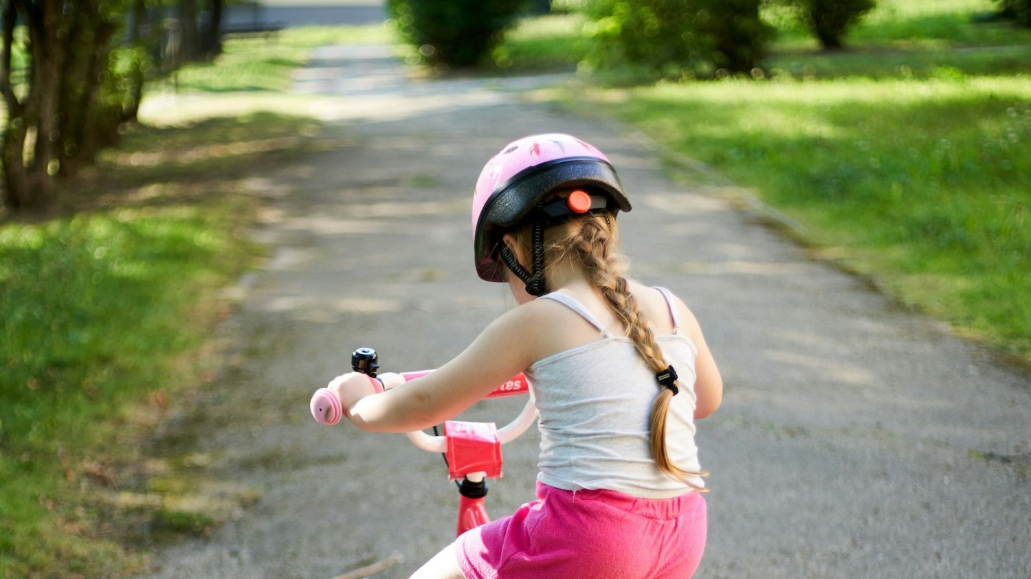 Obowiązkowy kask od czerwca 2026. Za jego brak będzie groził mandat. Na zdjęciu dziewczynka jedzie na rowerze.