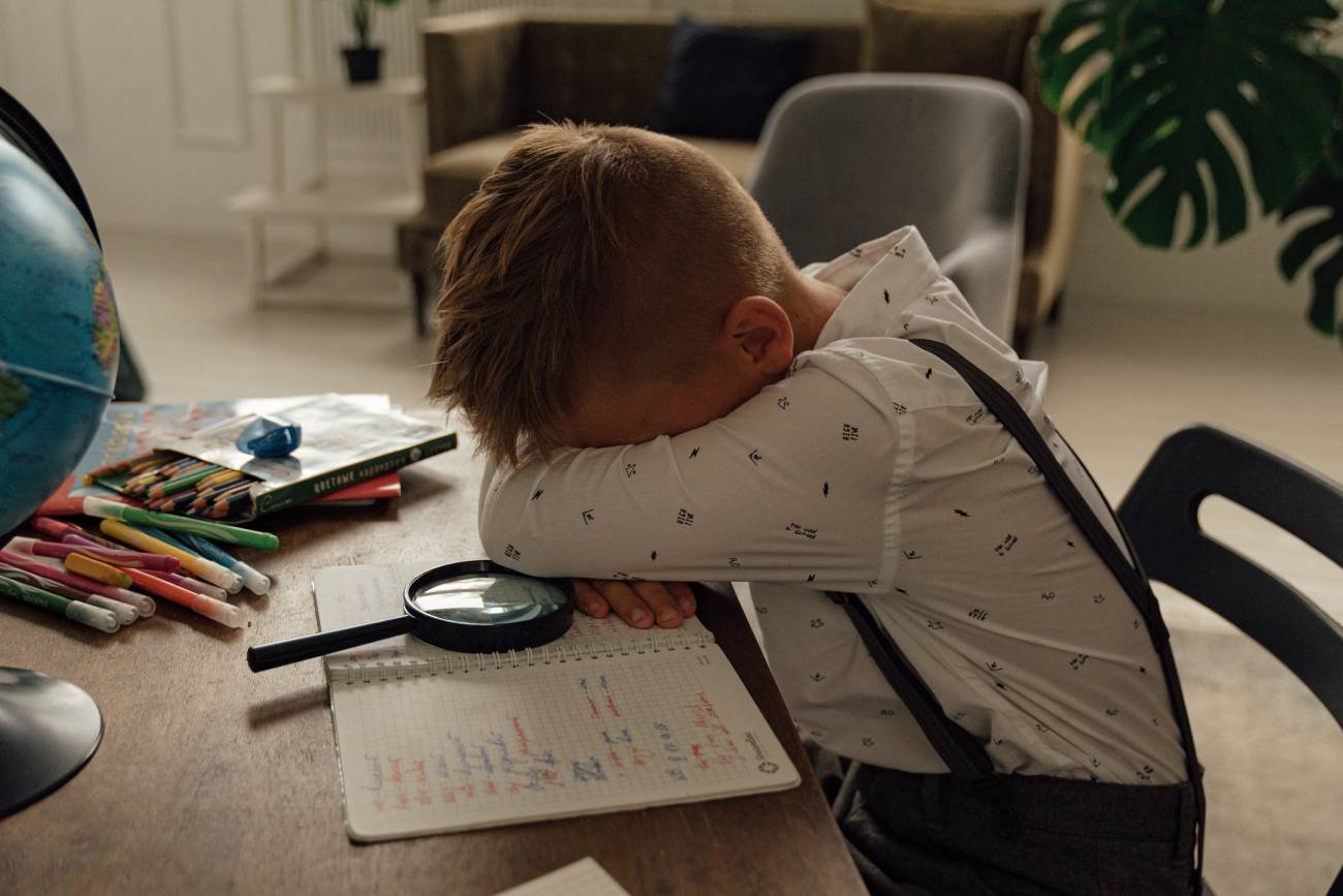 Chłopiec złości się i chowa głowę w ramionach.