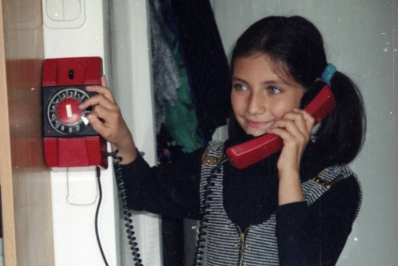 Dziewczynka rozmawia przez telefon stacjonarny.