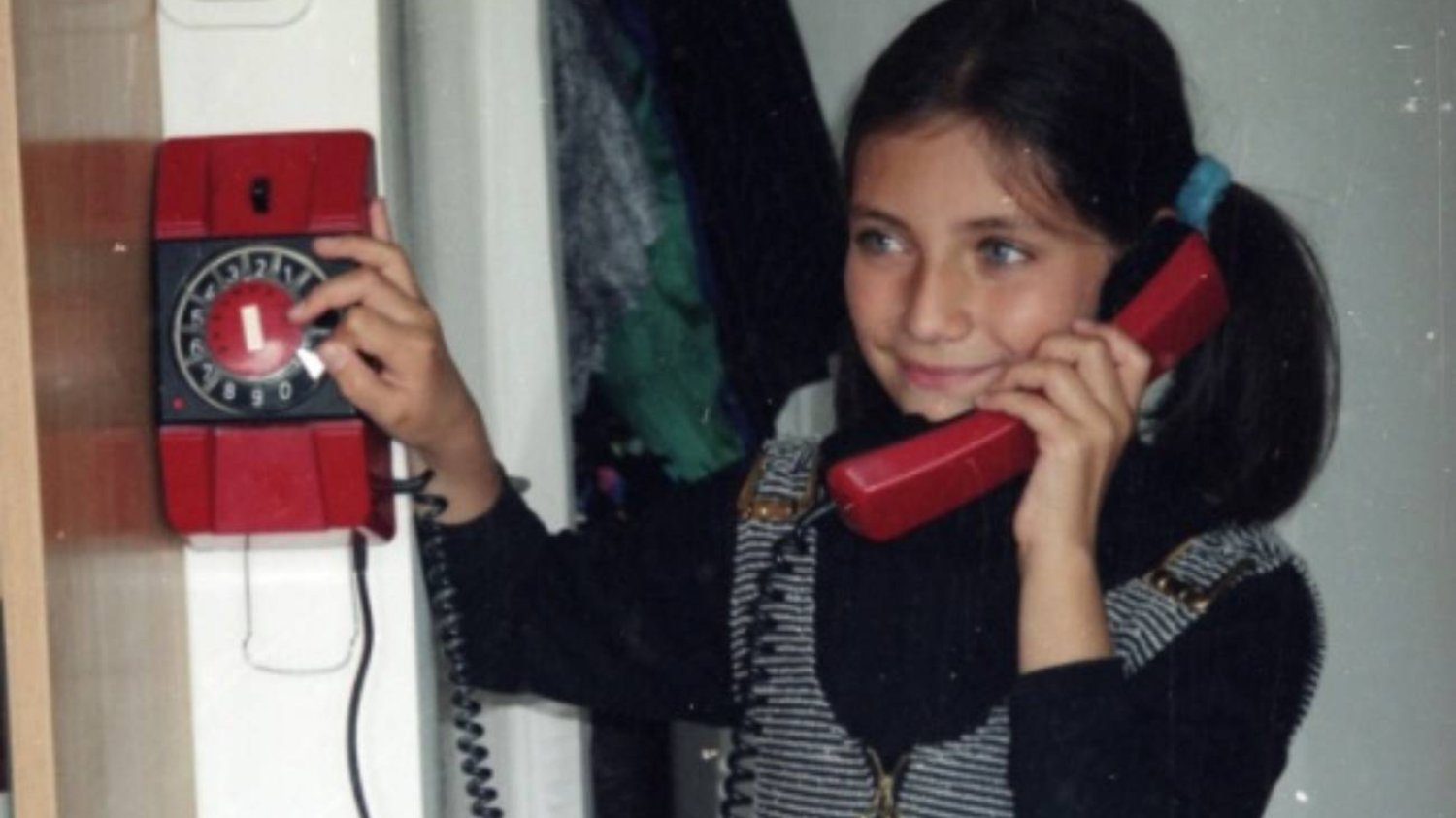 Dziewczynka rozmawia przez telefon stacjonarny.