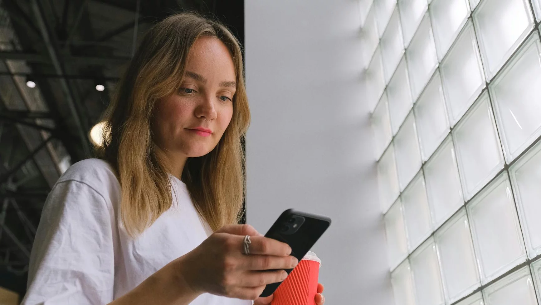 Zamrożenie ceny w Rossmannie. Zobacz, jak zatrzymać promocję na dłużej Na zdjęciu kobieta sprawdza coś w telefonie.