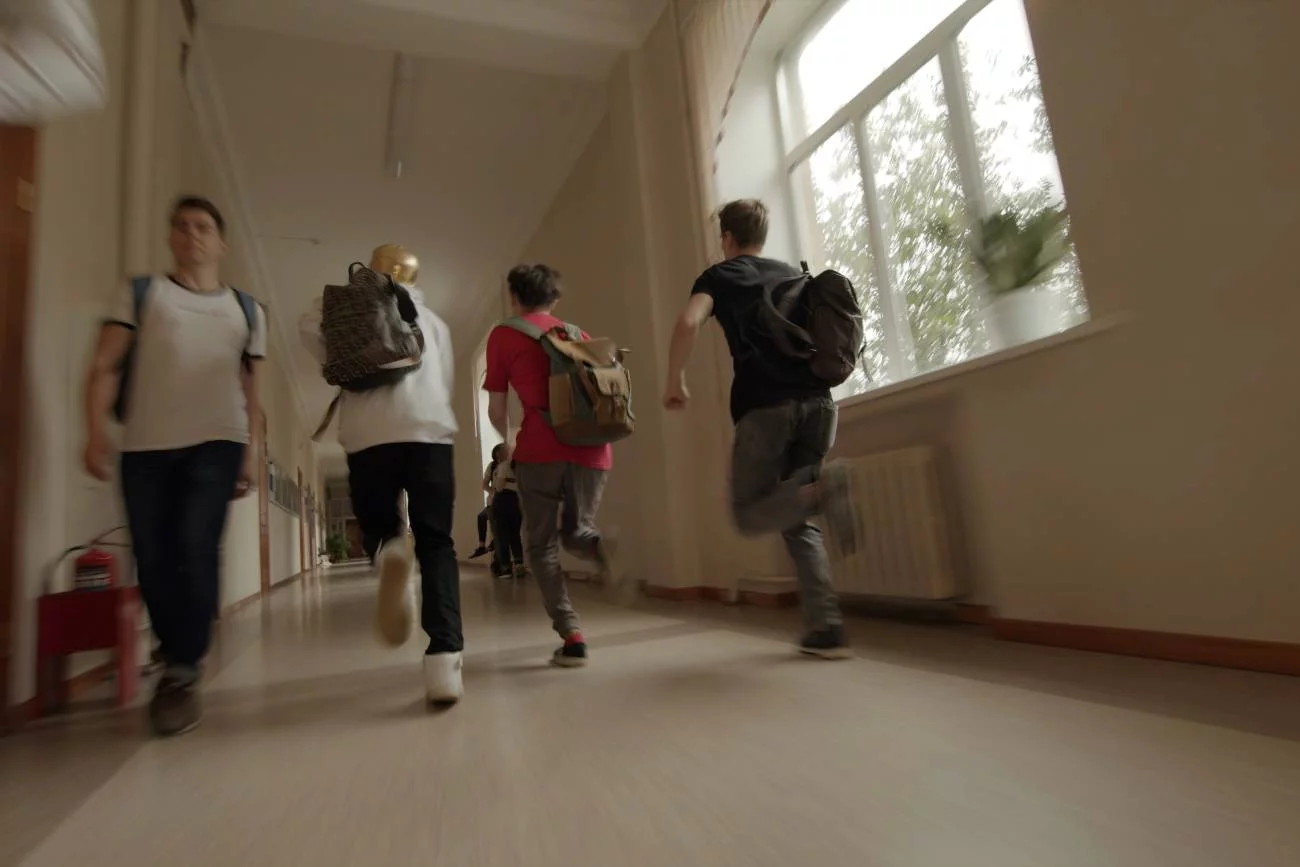 Uczniowie biegnący korytarzem podczas przerwy w lekcjach.