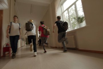 Uczniowie biegnący korytarzem podczas przerwy w lekcjach.